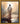 Gabriel Heaton painting of Jesus Christ seen from behind walking into brilliant white light reflected in calm water surrounded by dramatic clouds