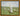 Gabriel Heaton painting of Jesus Christ as the Good Shepherd standing in a green meadow holding a staff with a flock of white sheep in the background