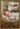 Gabriel Heaton painting of the baby Jesus sleeping in a golden straw manger with a white lamb resting beside him in soft warm light