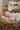 Gabriel Heaton painting of the baby Jesus sleeping in a golden straw manger with a white lamb resting beside him in soft warm light