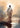 Gabriel Heaton painting of Jesus Christ seen from behind walking into brilliant white light reflected in calm water surrounded by dramatic clouds