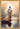 Gabriel Heaton painting of Jesus Christ seen from behind walking into brilliant white light reflected in calm water surrounded by dramatic clouds