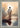 Gabriel Heaton painting of Jesus Christ seen from behind walking into brilliant white light reflected in calm water surrounded by dramatic clouds